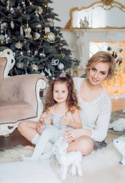 Girl  and mother near Christmas tree Royalty Free Stock Photos