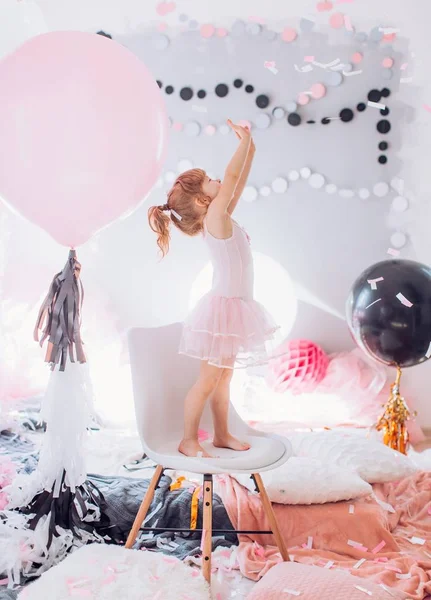 Babymeisje met ballonnen in de kamer — Stockfoto