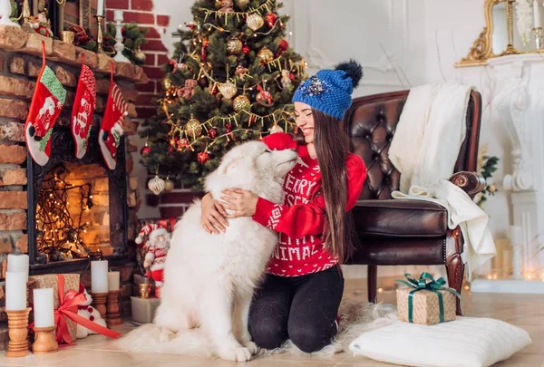 Kvinna nära julgranen med samojedvalpar hund — Stockfoto