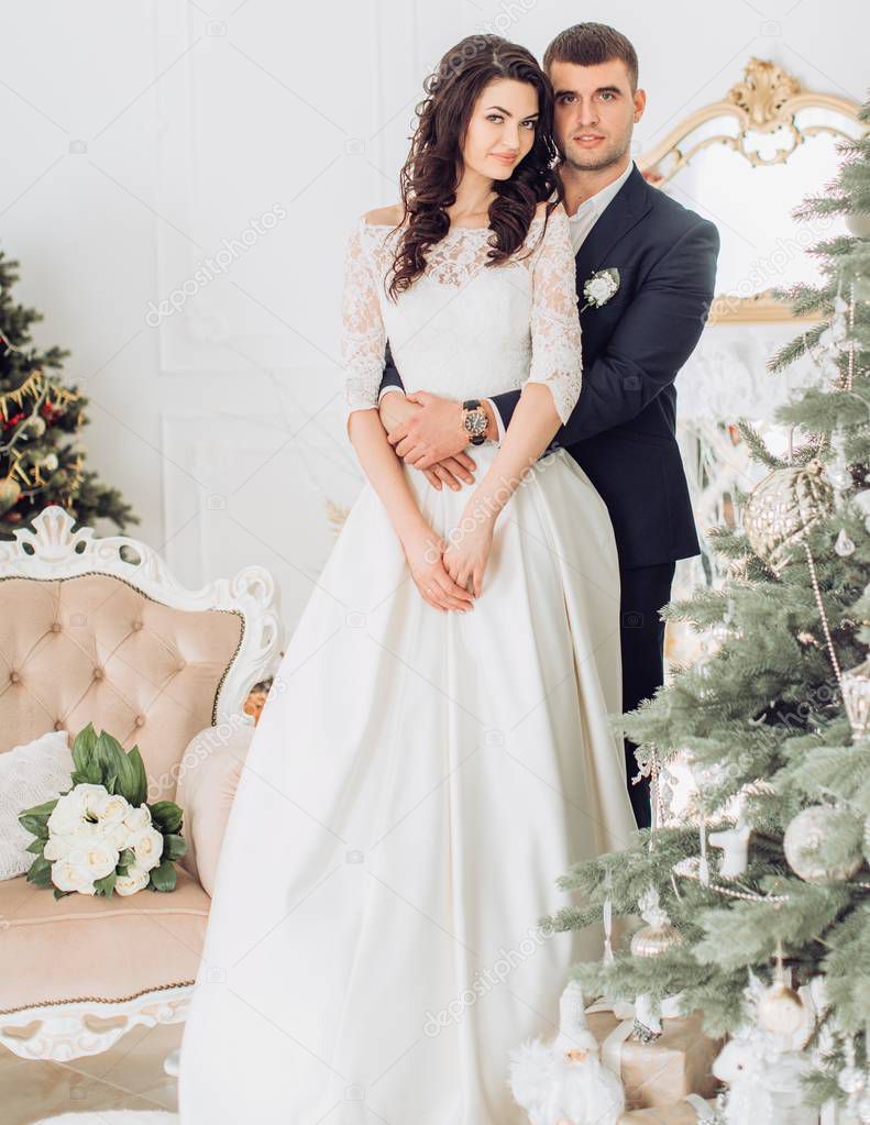 bride and groom near Christmas tree