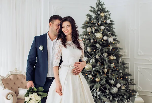 Bride and groom near Christmas tree — Stock Photo, Image