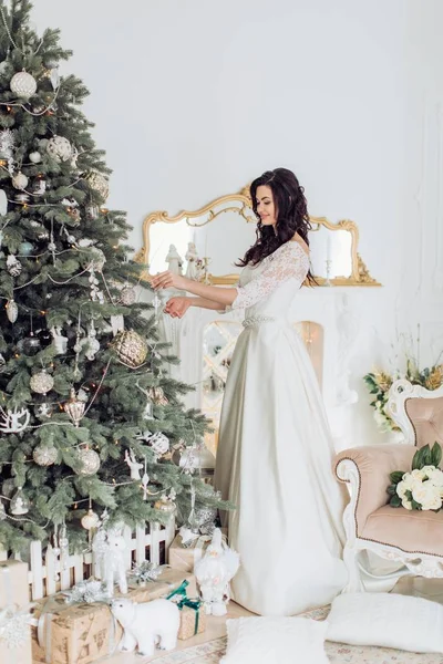 Jonge vrouw in de buurt van de kerstboom — Stockfoto