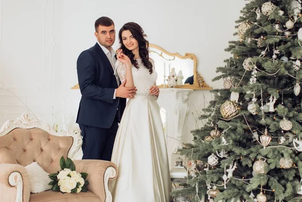 Bride and groom near Christmas tree — Stock Photo, Image