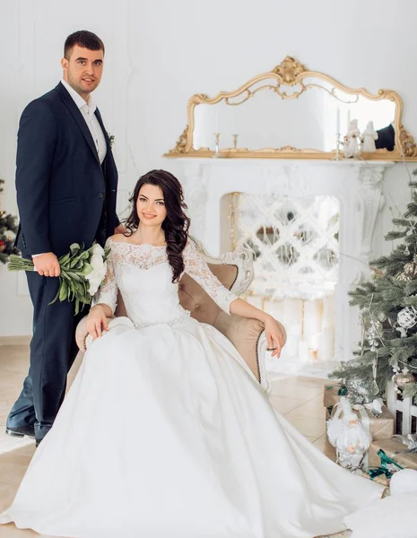 Bruden och brudgummen nära julgran — Stockfoto