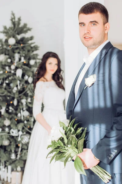 Νύφη και γαμπρός κοντά στο χριστουγεννιάτικο δέντρο — Φωτογραφία Αρχείου