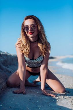  Kumsalda mayo giymiş genç bir kadın.