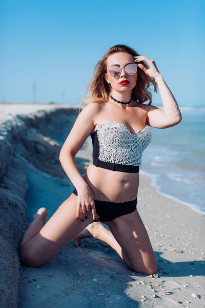  Kumsalda mayo giymiş genç bir kadın.