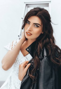 Genç kadın beyaz elbisenin içinde poz