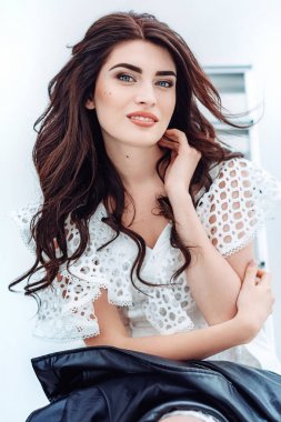 Genç kadın beyaz elbisenin içinde poz