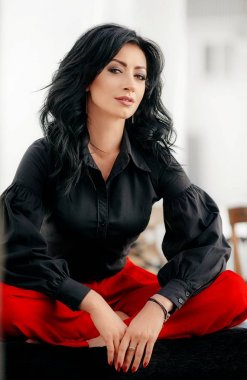 esmer kadın kırmızı pantolonuyla poz