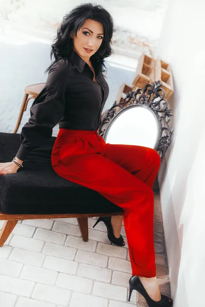 Genç kadın kırmızı pantolonuyla poz — Stok fotoğraf