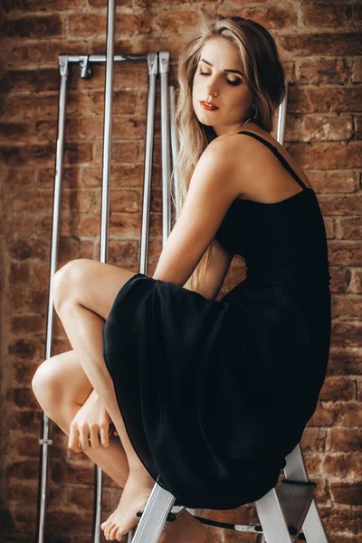 Блондинка позує в чорній сукні — стокове фото