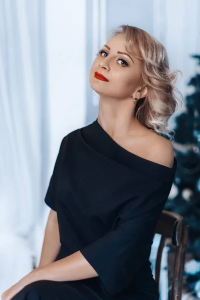 Blonde Frau posiert im schwarzen Kleid — Stockfoto