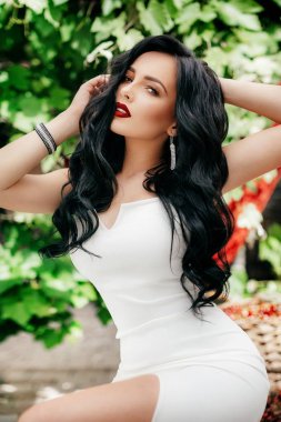 Genç kadın beyaz elbisenin içinde poz 