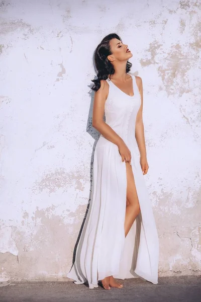 kadın beyaz bir elbiseyle poz 