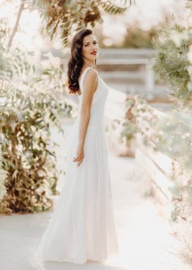 kadın beyaz bir elbiseyle poz 