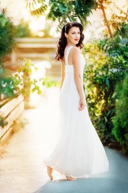 kadın beyaz bir elbiseyle poz 