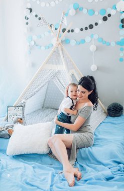 Genç anne ve onun güzel bebek çocuk evde çadır yakınındaki.