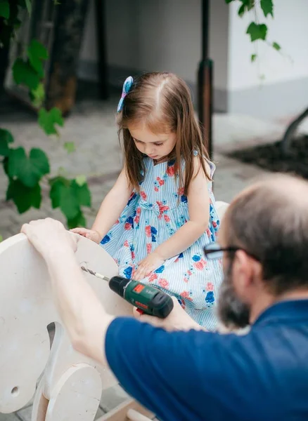 Niedliche Kleine Glückliche Mädchen Auf Holzpferd Und Ihr Großvater — Stockfoto