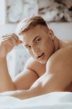 Güçlü sağlıklı yakışıklı atletik erkek yatakta poz portresi