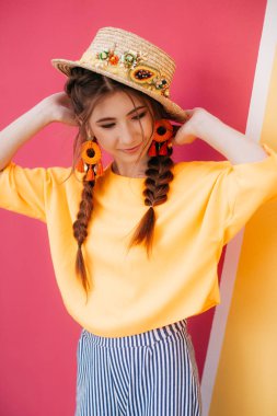 İki örgülü ve hasır şapkalı güzel bir genç kadın. 