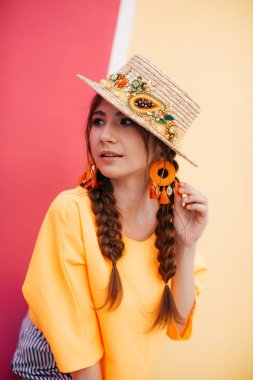 İki örgülü ve hasır şapkalı güzel bir genç kadın. 