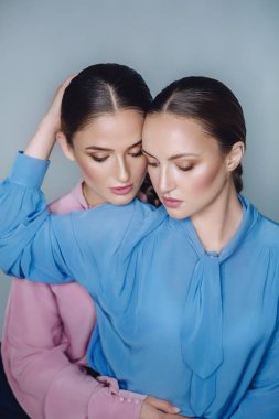 Mavi ve pembe gömlekli güzel kadınlar.