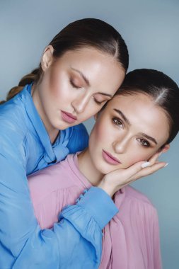 Mavi ve pembe gömlekli güzel kadınlar.