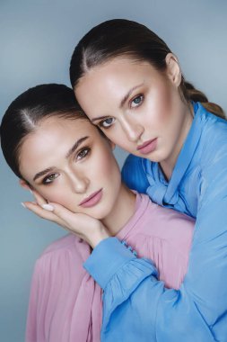 Mavi ve pembe gömlekli güzel kadınlar.