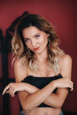 Siyah bluzlu güzel sarışın bir kadının portresi.