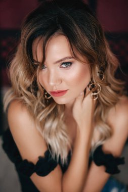 Siyah bluzlu güzel sarışın bir kadının portresi.