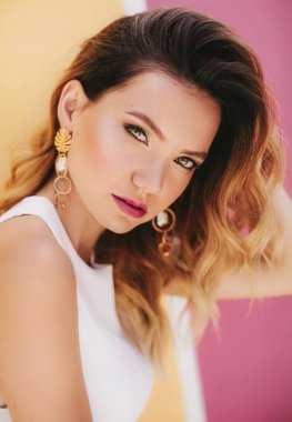 Beyaz bluzlu güzel sarışın bir kadının portresi.