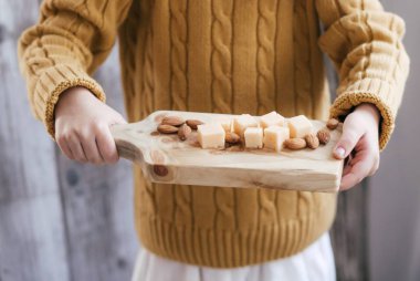 Tahtada peynirle poz veren küçük kız.