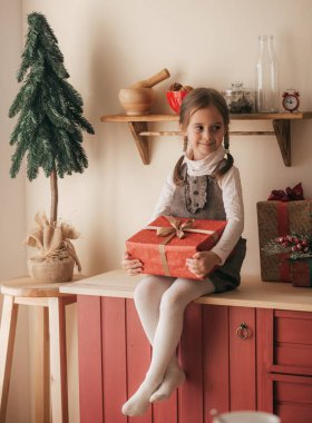 Küçük kız Noel 'in içinde hediyeyle poz veriyor.