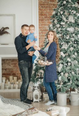 Noel arifesinde anne babası poz veren sevimli küçük bir çocuk. 