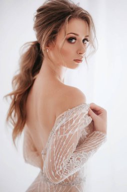 Sırtı çıplak, uzun elbiseli güzel bir kadının portresi.