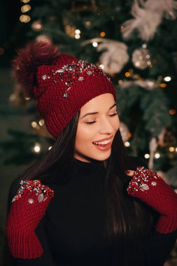 Güzel bir kadın kışlık şapka ve eldivenlerle poz veriyor.