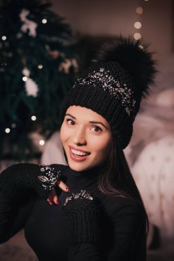 Güzel bir kadın kışlık şapka ve eldivenlerle poz veriyor.