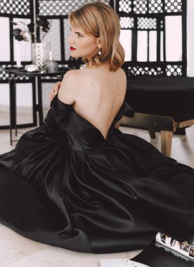 Siyah elbiseli güzel sarışın kadının portresi.