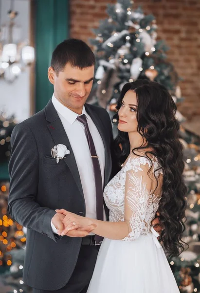 美しいと若い花嫁と新郎はクリスマスツリーの近くにポーズ — ストック写真