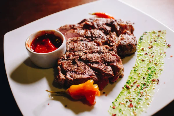 Bife Ribeye Com Molho Vegetal Uma Placa Branca — Fotografia de Stock