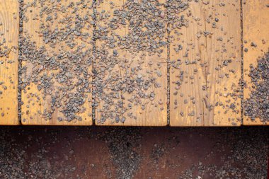 Ahşap tahtaların dokusu ve ince çakıl parçaları.