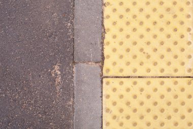 Kaldırımda görme engelliler için parlak sarı asfalt döşeme.