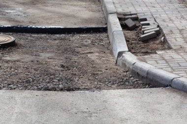 İnşaat çalışmaları, yol onarımı, yeni asfalt için hazırlanırken verandaya kaldırım tuğlaları yerleştiriliyor