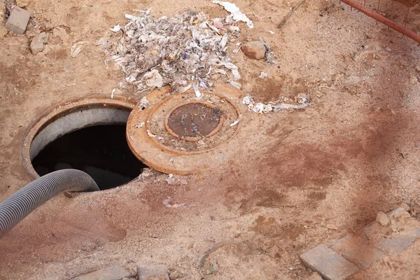 Kanalizasyon kapağından özel bir hortumla atık su pompalamak