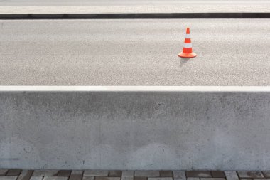 Yolu ve kaldırımı ayıran büyük beton çitli arabalar için Bitumen kaldırım yolundaki trafik konisi