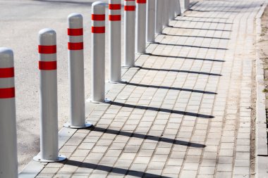A barrier made of plastic columns with reflective pigment on an asphalt road. Danger concept clipart