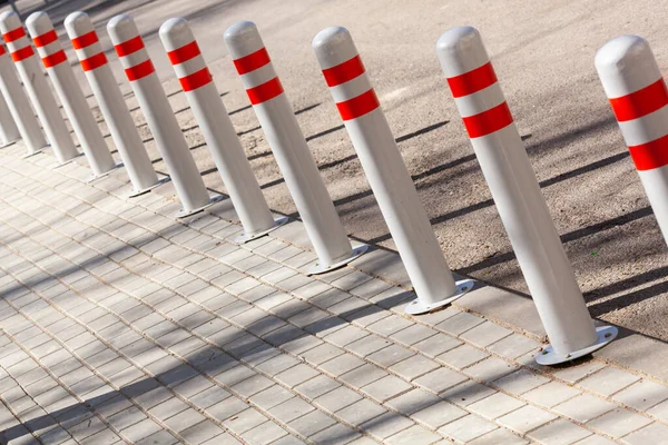 Una barrera hecha de columnas de plástico con pigmento reflectante en una carretera asfaltada. Concepto de peligro — Foto de Stock
