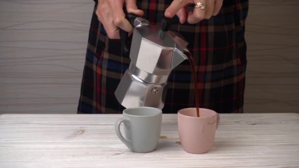 Vrouw koffie uit een geiser koffiezetapparaat gieten — Stockvideo