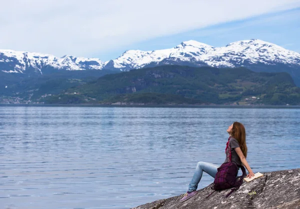 Meisje op een fjord kust lezen — Stockfoto